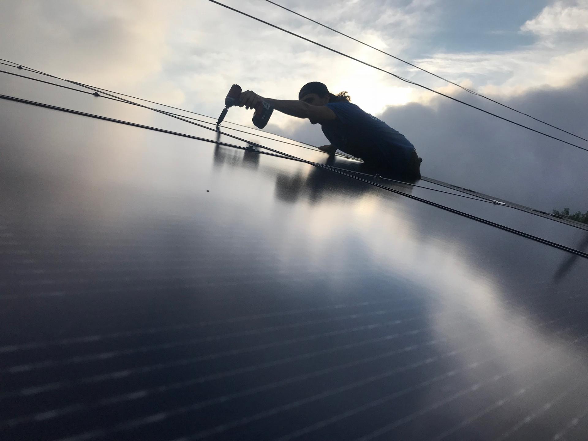 Man bolting down solar panel